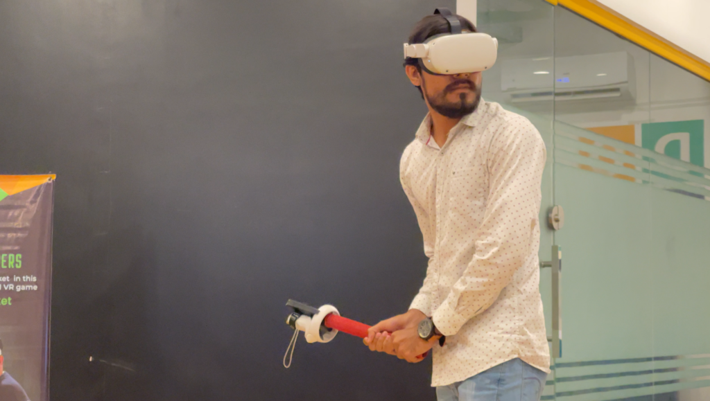 A user is playing virtual reality cricket game, Final Overs, using VR Pro Cricket Bat